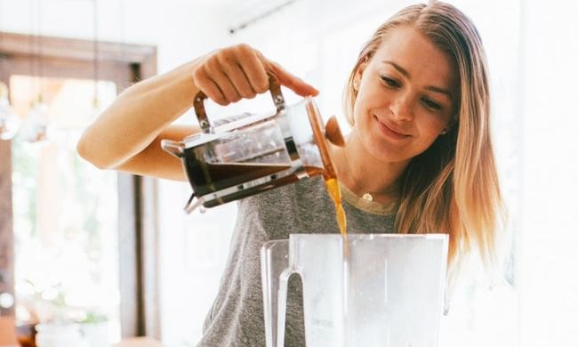 フレンチプレスでコーヒーを淹れる女性